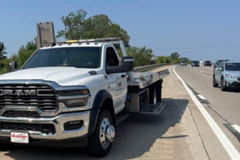Safeway Services flatbed tow truck stopped on a highway shoulder beside passing traffic
