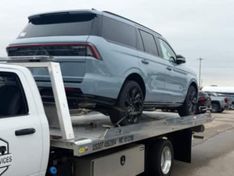 Lincoln Navigator strapped down on a Safeway Services flatbed